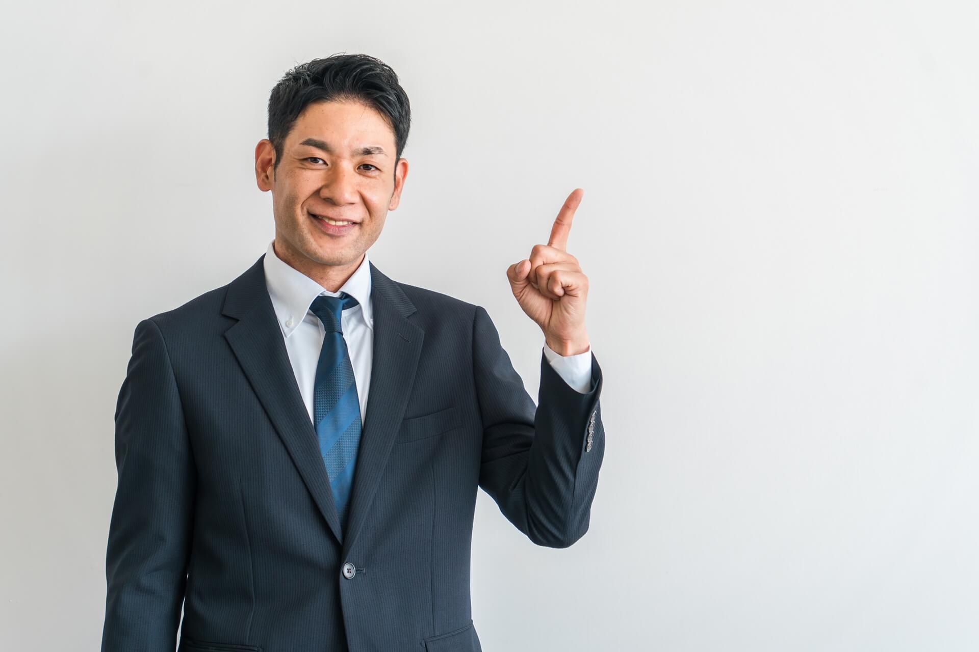 指を指すスーツ姿のビジネスマン
