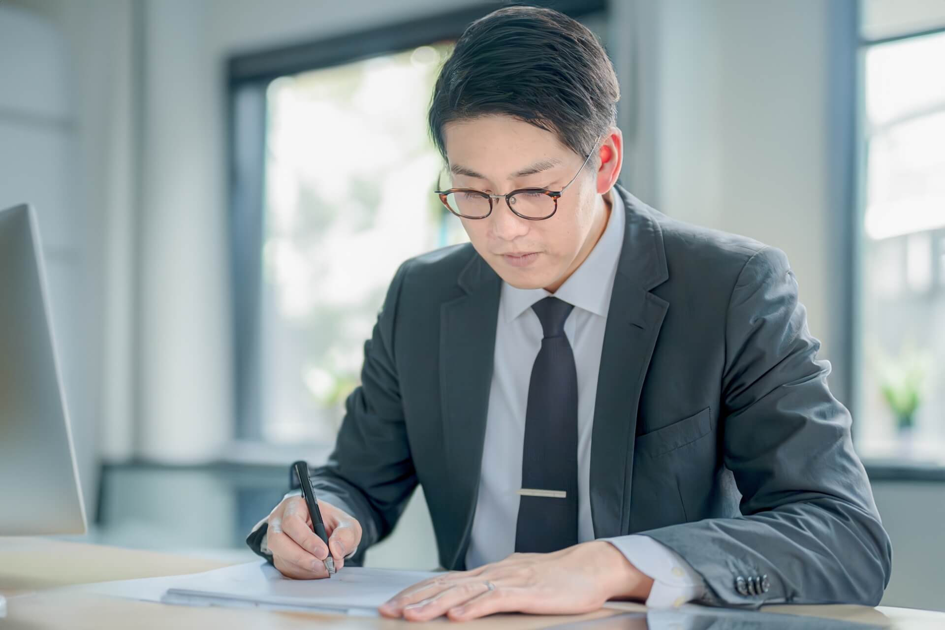 書類に署名するスーツ姿の男性